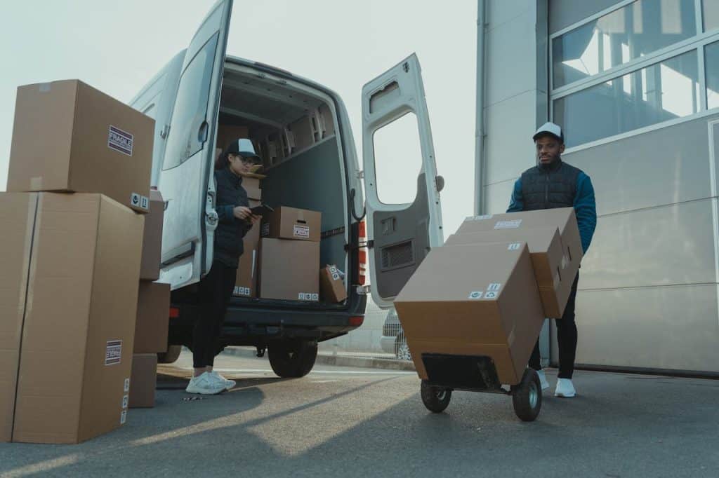 Delivery workers loading boxes into van at Newdawn Automation facility.